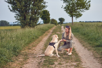 Junge Frau h&auml;lt die Pfote ihres Hundes in der Hand