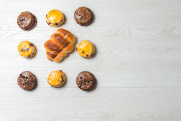 closeup delicious sausage bread roll and fresh tasty scones on wooden table