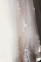 beautiful floral detail on silk wedding dress. lace ornament on white gown, bridal morning preparations
