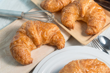 breakfast bakery concept : fresh french croissant on wooden background