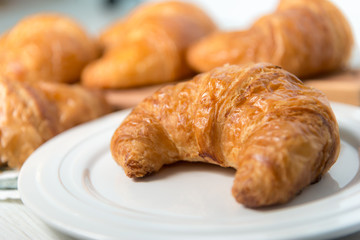 breakfast bakery concept : fresh french croissant on wooden background