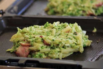 ジャガイモとベーコンのお好み焼きを焼いているところ