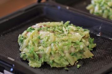 ジャガイモとベーコンのお好み焼きを焼いているところ