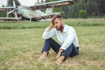 a man sitting on the grass at the old plane