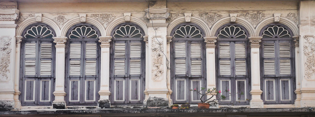 a row of old vintage windows on a street in the city.