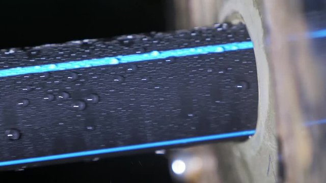 Pipes manufacturing production line. Manufacture of plastic water pipes of the factory. Process of making plastic tubes on the machine tool with the use of water and air pressure.