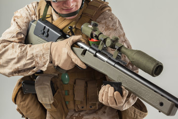 Soldier in camouflage holding rifle