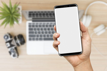 Hand holding a Modern Smartphone with travel blurry background