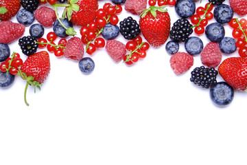 Bunch of mixed berries in harvest pile on white background. Colorful composition with fresh organic strawberry, blueberry, blackberry & redcurrant. Clean eating concept. Close up, copy space, top view