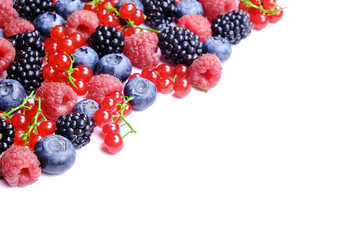 Bunch of mixed berries in harvest pile on white background. Colorful composition with fresh organic strawberry, blueberry, blackberry & redcurrant. Clean eating concept. Close up, copy space, top view