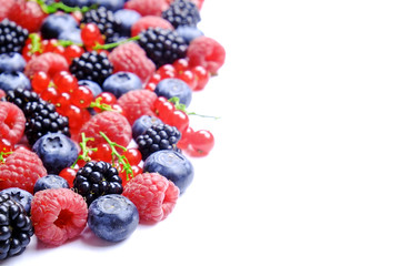 Bunch of mixed berries in harvest pile on white background. Colorful composition with fresh organic strawberry, blueberry, blackberry & redcurrant. Clean eating concept. Close up, copy space, top view