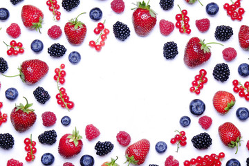 Bunch of mixed berries in harvest pile on white background. Colorful composition with fresh organic strawberry, blueberry, blackberry & redcurrant. Clean eating concept. Close up, copy space, top view