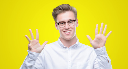 Young handsome blond man showing and pointing up with fingers number nine while smiling confident...