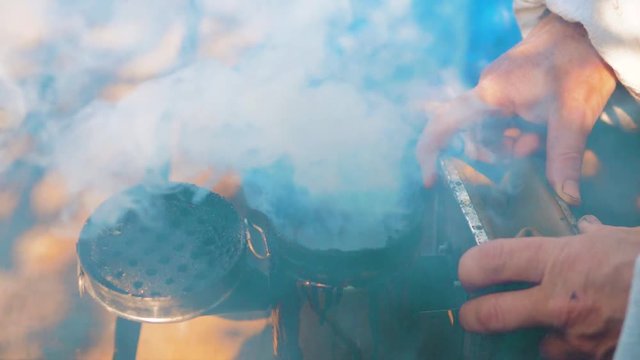 bee-maker of a smoke pipe beeper smoker device for repelling evil bees. slow motion video apiary. beekeeping concept bee agriculture lifestyle