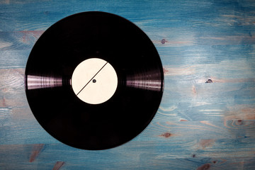 Black color vinyl record on blue wooden background