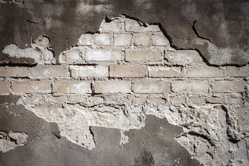Old gray brick and plaster wall texture background