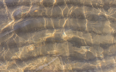 Fototapeta na wymiar The background of sand on the seabed through layer of clear and transparent sea water