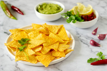 A traditional Mexican snack nachos served with sauces of guacamole, pico de gallo or salsa.