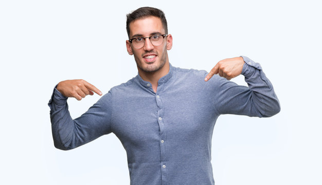 Handsome young elegant man wearing glasses looking confident with smile on face, pointing oneself with fingers proud and happy.