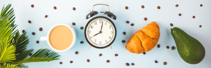 morning coffee in a white cup Croissant Avocado Awakening with an alarm clock Breakfast...