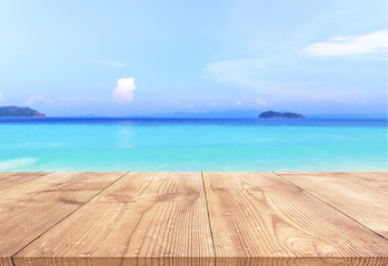 Fototapeta premium Wood table with blue sea and sand beach background