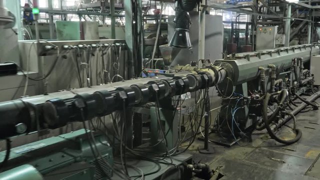 Pipes manufacturing production line. Manufacture of plastic water pipes of the factory. Process of making plastic tubes on the machine tool with the use of water and air pressure.