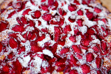 Homemade baked strawberry pie with sugar white powder, top view, close-up