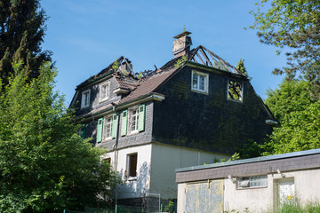 ausgebranntes Haus mit verfallenem Dachstuhl mit verkohlten Dachbalken