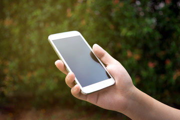 Hands holding smart phone outdoor, black screen.