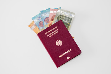 German passprt filled with different euro banknotes isolated on white background