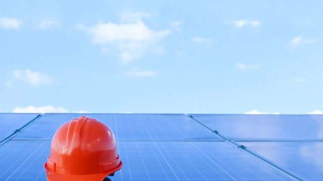 Construction helmet on solar cell panel farm or electricity power station	