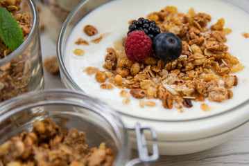 Jars full with granola, yogurt and fresh berries, close-up, selective focus