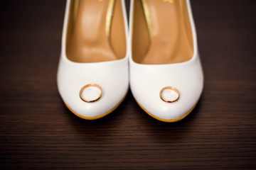 White bridal shoes and wedding rings