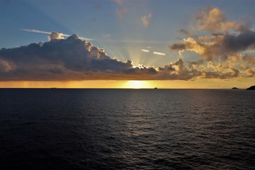 Naklejka na ściany i meble Beautiful sunset over the ocean with cloudy skies