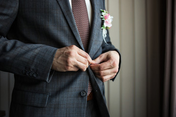 Businessman wears a jacket,male hands closeup,groom getting ready in the morning before wedding...