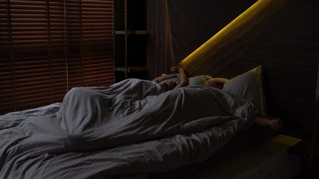 Husband with wife asleep in bed and wake up