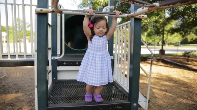 Little Girl Swinging on Monkey Bars