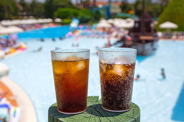Glasses with cola and ice at the pool on summer holidays