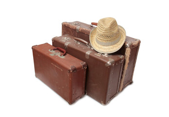 Old suitcase and a straw hat on a white background