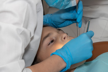 Naklejka premium children's dentist conducts a professional examination of the girl