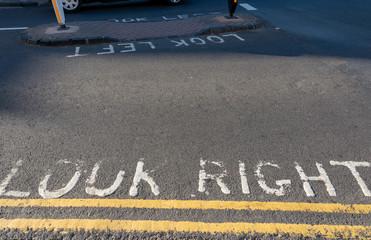 road signs telling pedestrians to look right and to look left with double yellow parking...