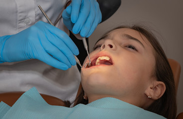 children's dentist conducts a professional examination of the girl