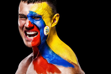 Soccer or football fan with bodyart on face with agression - flag of Colombia.
