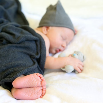 newborn baby sleeping in the arms of a toy