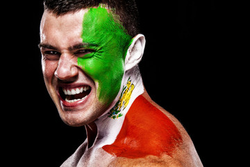Soccer or football fan with bodyart on face with agression - flag of Spain.