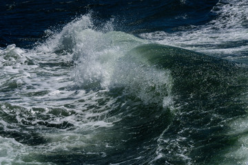 Close up of breaking waves as a nature background, green water, white water and foam
