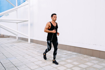 Muscular man running outdoors.