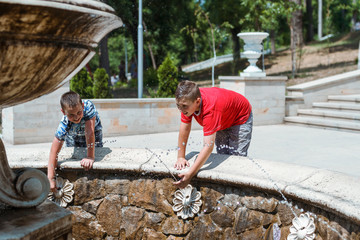 Kids having fun under a water fountain