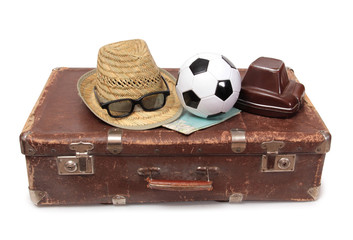 Old suitcase and soccer ball on white background