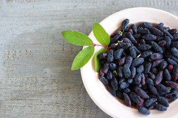 Honeysuckle berries in Cup on table with copy space